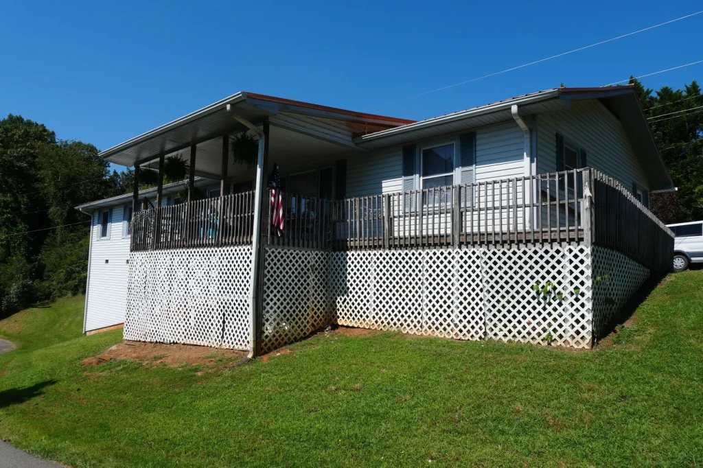 A home with a covered porch and a raised deck along one side.